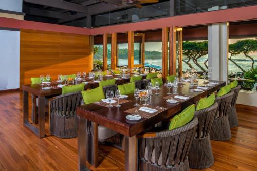 a dining room with a long table and green chairs at Mauna Kea Beach Hotel, Autograph Collection in Hapuna Beach