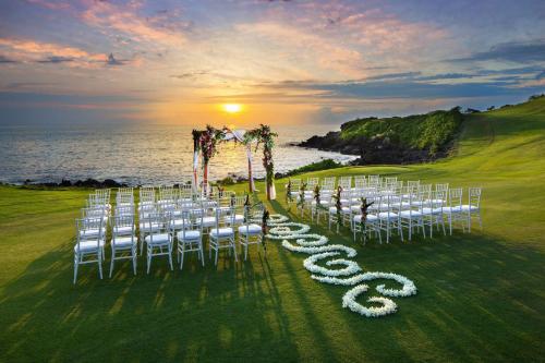 a row of white chairs in front of the ocean at Mauna Kea Beach Hotel, Autograph Collection in Hapuna Beach