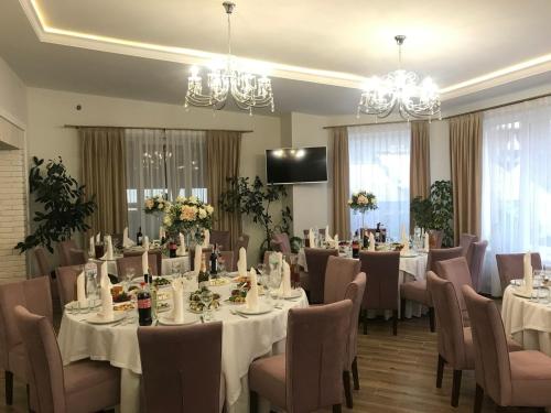 Hotel Sofiivka في Konopnitsa: قاعة اجتماعات مع طاولات وكراسي وثريات