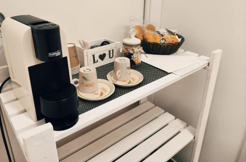 a coffee maker and two plates on a shelf at Alba b&b in Polignano a Mare
