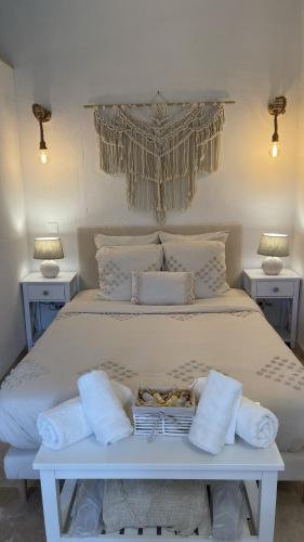 - un lit blanc avec des oreillers et des serviettes dans l'établissement Insolite : Gîte Namaste à 500m à pied du Zoo de Beauval, à Seigy