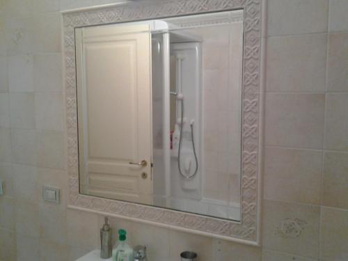 a mirror over a sink in a bathroom at Apartment Largo del Teatro in Porto San Giorgio