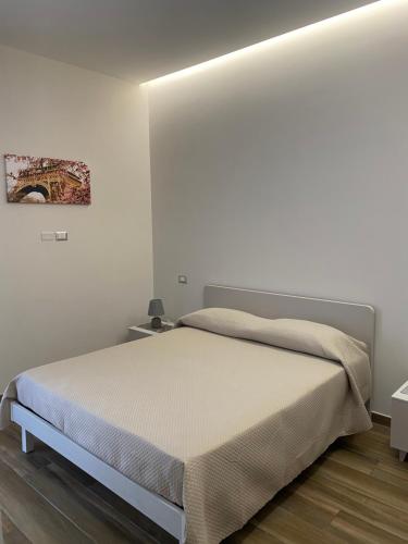 1 dormitorio con 1 cama en una habitación blanca en Villa Rose Apartments, en Sant'Egidio del Monte Albino