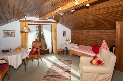 ein Wohnzimmer mit einem Bett, einem Tisch und Stühlen in der Unterkunft Haus St. Korbinian in Mittenwald
