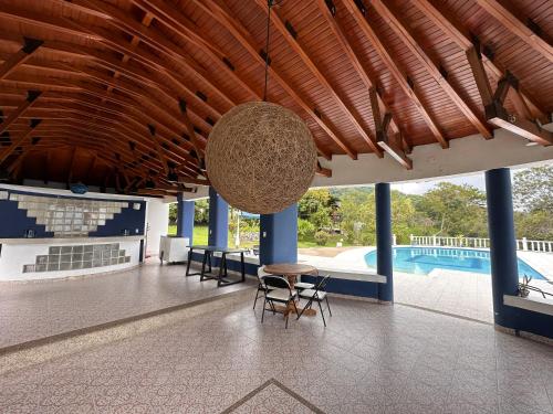 hol ze stołem i krzesłami oraz basenem w obiekcie Hacienda Siete Sentidos w mieście Anapoima