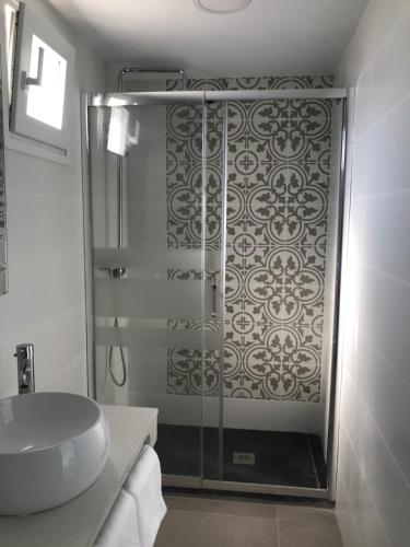 a bathroom with a glass shower and a sink at LIOMA VELLA 1 in Peniscola