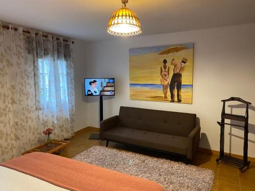 a living room with a couch and a painting at CasaNova in Combarro