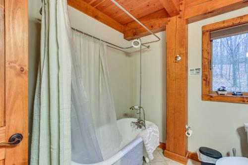 een badkamer met een bad en een douchegordijn bij Spacious Virginia Vacation Rental with Yard and Sauna in Purcellville