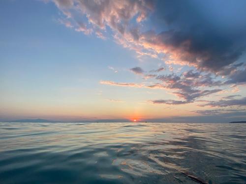 a sunset over the ocean with the water at Isidora Summer House in Skála Foúrkas