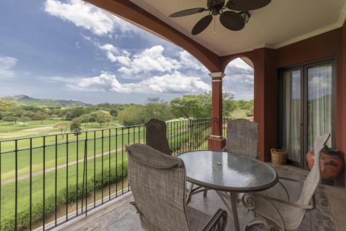 a porch with a table and chairs and a balcony with a view at Bougainvillea 5306 Luxury Apartment - Reserva Conchal in Playa Conchal