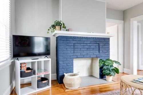 a living room with a blue brick fireplace at Private Boho Bungalow 10 Minutes to Downtown RVA! in Richmond