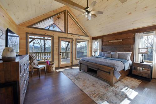1 dormitorio con 1 cama y ventilador de techo en Fox Den - Amazing cabin, view, hot tub and more!, en Blue Ridge