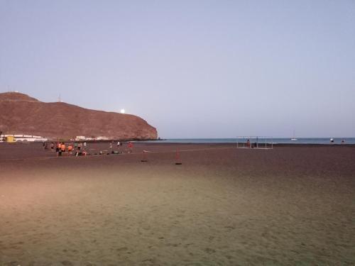 a beach with a group of people and the ocean at The Apartment in Gran Tarajal