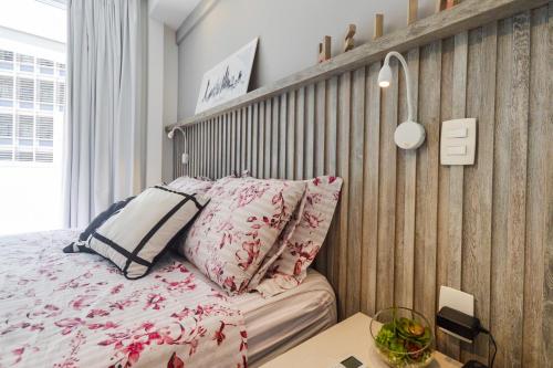 a bedroom with a bed and a wooden wall at Loft Downtown São Luis, 612 in Sao Paulo