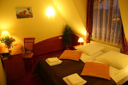 a hotel room with two beds and a window at Hotel Karolinka in Gogolin