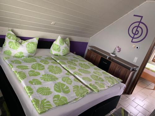 a bed with green and white sheets and pillows at Ferienwohnung/Monteurwohnung SZ-Reiki in Erbendorf