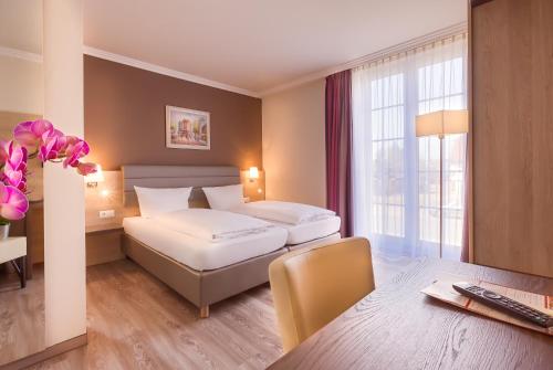 a hotel room with two beds and a desk at Hotel Rosenhof bei Bamberg in Kemmern