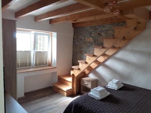 1 dormitorio con escalera, cama y ventana en Apartment Vignole, en Portorož