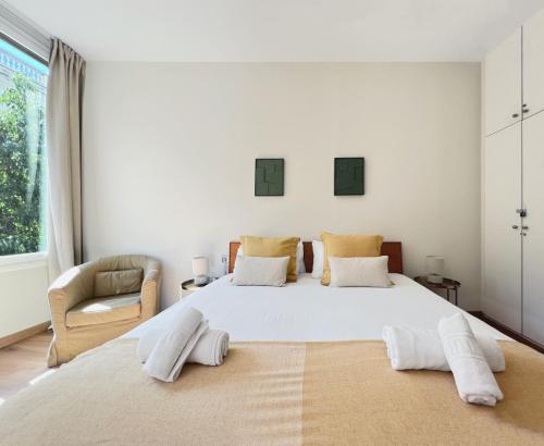 a bedroom with a large white bed and a chair at Stay U-nique Apartments Fontanella in Barcelona