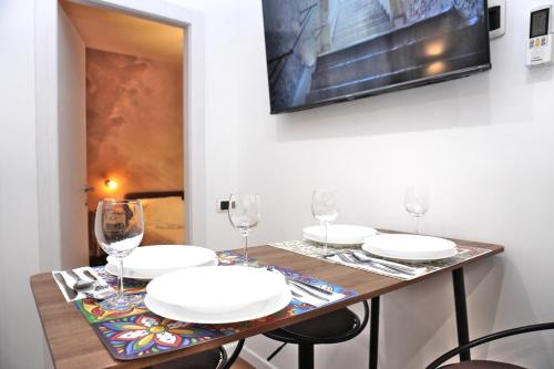 a table with white plates and glasses on it at Elegantis Vatican Suite Apartment in Rome