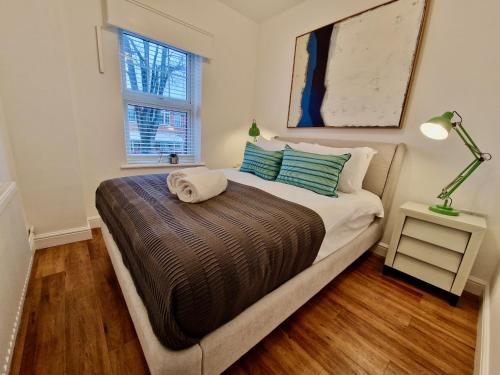 a bedroom with a bed and a lamp and a window at Trendy Luxury Serviced Apartment next to City Centre with Free Parking - Contractors & Relocators in Coventry
