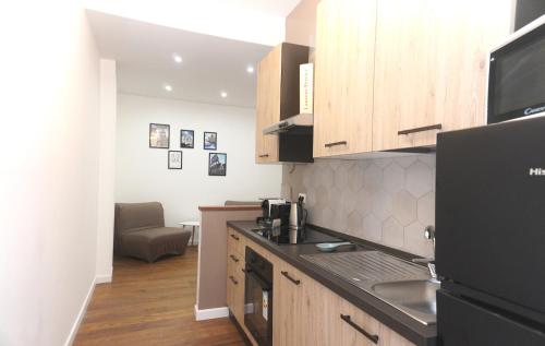 a kitchen with a black refrigerator and wooden cabinets at Vatican Suite Apartment - Rome City Centre in Rome