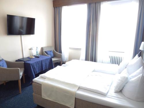 a hotel room with a bed and a table and a tv at Hotel Rheinischer Hof in Bad Breisig