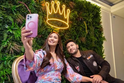 a man and a woman taking a picture with a pink phone at Hotel Virrey Central in Bogotá