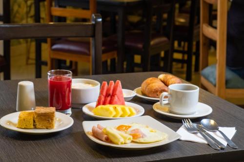 a table topped with plates of breakfast foods and drinks at Hotel Virrey Central in Bogotá