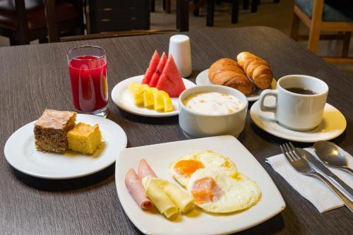 a table with plates of breakfast foods and a cup of coffee at Hotel Virrey Central in Bogotá