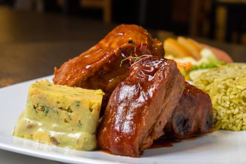 a plate of food with meat and cheese and rice at Hotel Virrey Central in Bogotá