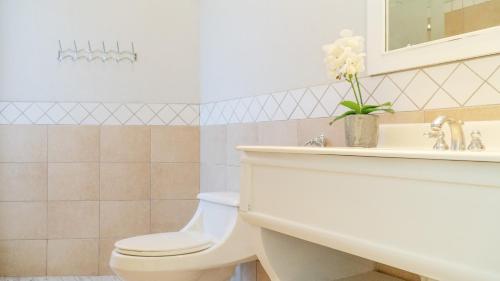 a bathroom with a toilet and a sink at Bougainvillea 2102 Luxury Apartment - Reserva Conchal in Playa Conchal