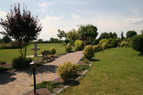 a park with a bench and a fountain at Hotel Karolinka in Gogolin