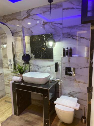 a bathroom with a sink and a marble wall at Candi Luxury Suites in Neos Marmaras
