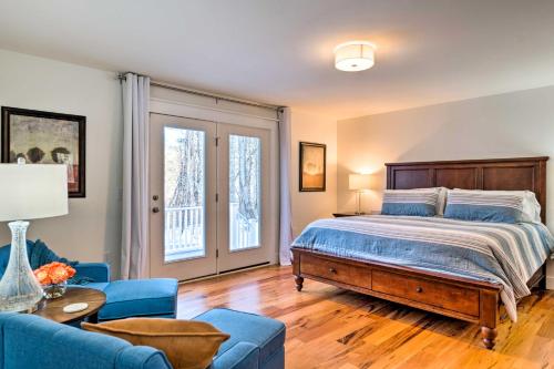 um quarto com uma cama e um sofá azul em 3-Acre Thetford Rental with River Access and Upgrades! 