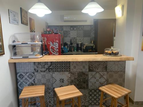 a kitchen with a counter with three stools at Residence R&B Tyrrhenum in Monte di Procida