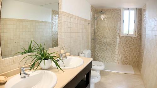 a bathroom with two sinks and a toilet and a shower at Villa Bendex Estepona Costa Del Sol in Estepona