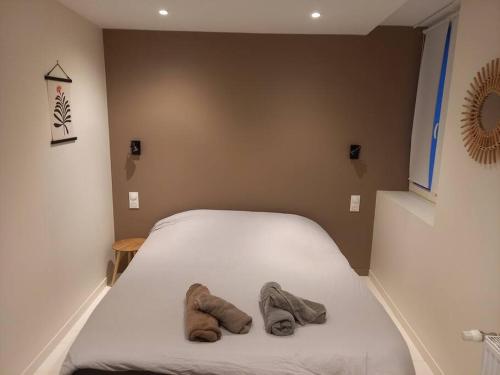 un lit avec deux paires de chaussures assises sur lui dans l'établissement Très bel appartement au pied du port l'Albâtre, à Saint-Valery-en-Caux