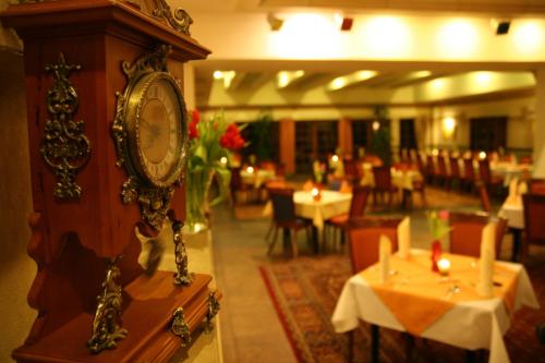 a clock on a wall in a restaurant with tables at Hotel Karolinka in Gogolin