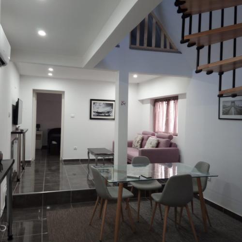 un salon avec une table en verre et des chaises dans l'établissement Maison Wintzenheim, à Wintzenheim