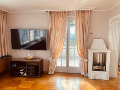 un soggiorno con una grande finestra e una TV a schermo piatto di Haus Bohle a Dornbirn
