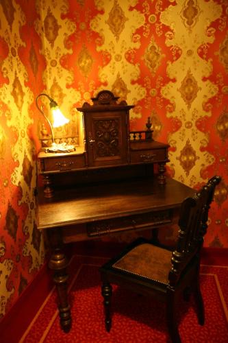 a desk with a lamp and a chair in a room at Hotel Karolinka in Gogolin