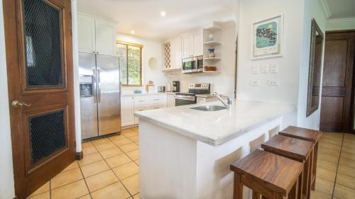 a kitchen with a sink and a refrigerator at Bougainvillea 3103 Luxury Apartment - Reserva Conchal in Playa Conchal