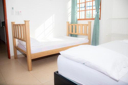 Habitación con 2 camas y 2 sillas. en CABAÑA BELÉN, en Santa Marta