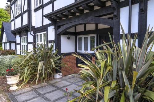 una casa en blanco y negro con plantas delante en Purdis Farm - Flat 4, en Bucklesham