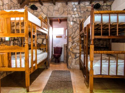 a room with bunk beds in a stone room at Hotel Restaurante Spa La Barca de Oro in Las Peñitas