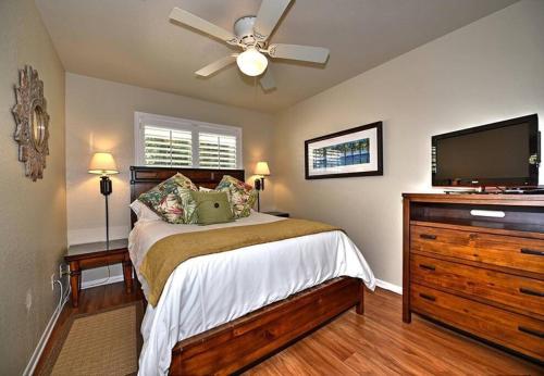 1 dormitorio con 1 cama y TV de pantalla plana en Comal Cottages River 403C, en New Braunfels