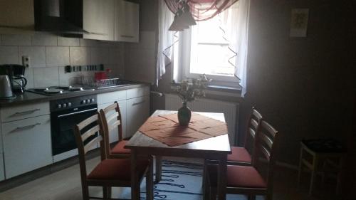 a kitchen with a table and chairs and a window at Wellness Hotel Pension & Gaststätte Riedel in Kurort Oberwiesenthal