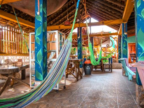 a hammock in a room with tables and chairs at Hotel Restaurante Spa La Barca de Oro in Las Peñitas
