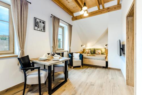 a room with a table and chairs and a bed at Penzion Zvon in Horní Stropnice